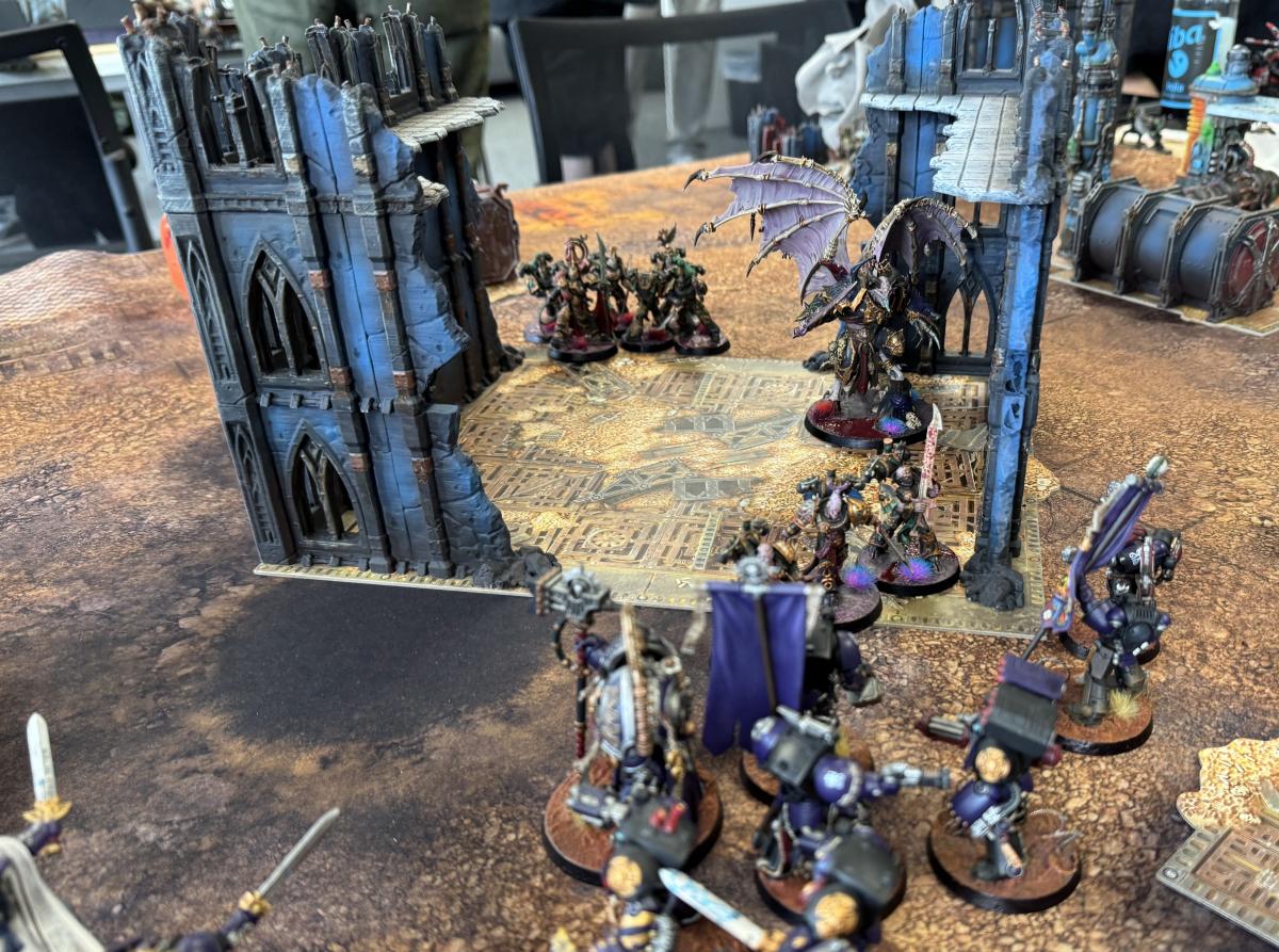 Gotische Ruinen und bemalte Armeen auf einem Warhammer 40k Geländetisch im TGM Münster