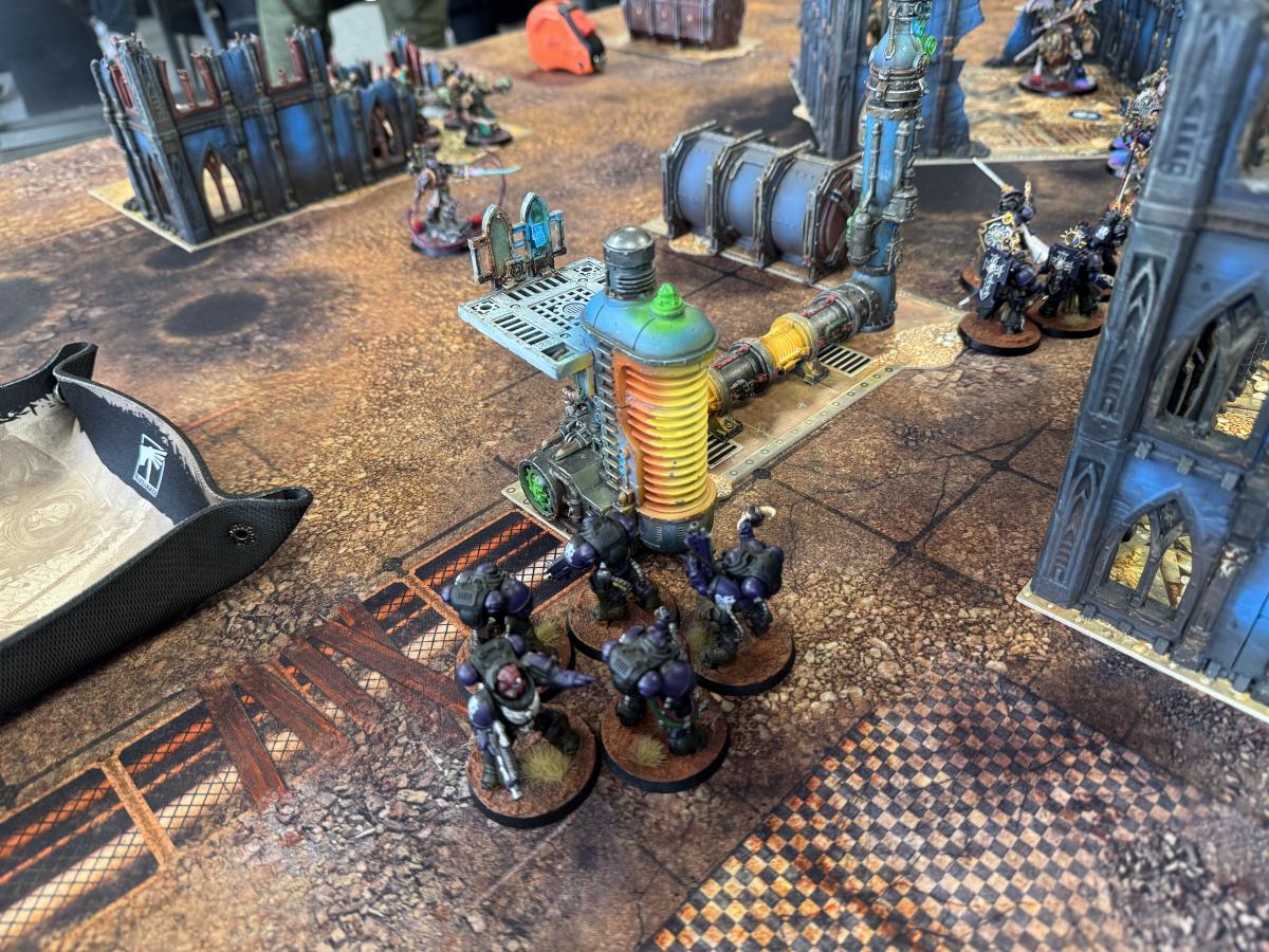 Aufgebautes Geländeset mit Industrieruinen auf einem Warhammer 40k Tisch im TGM Münster